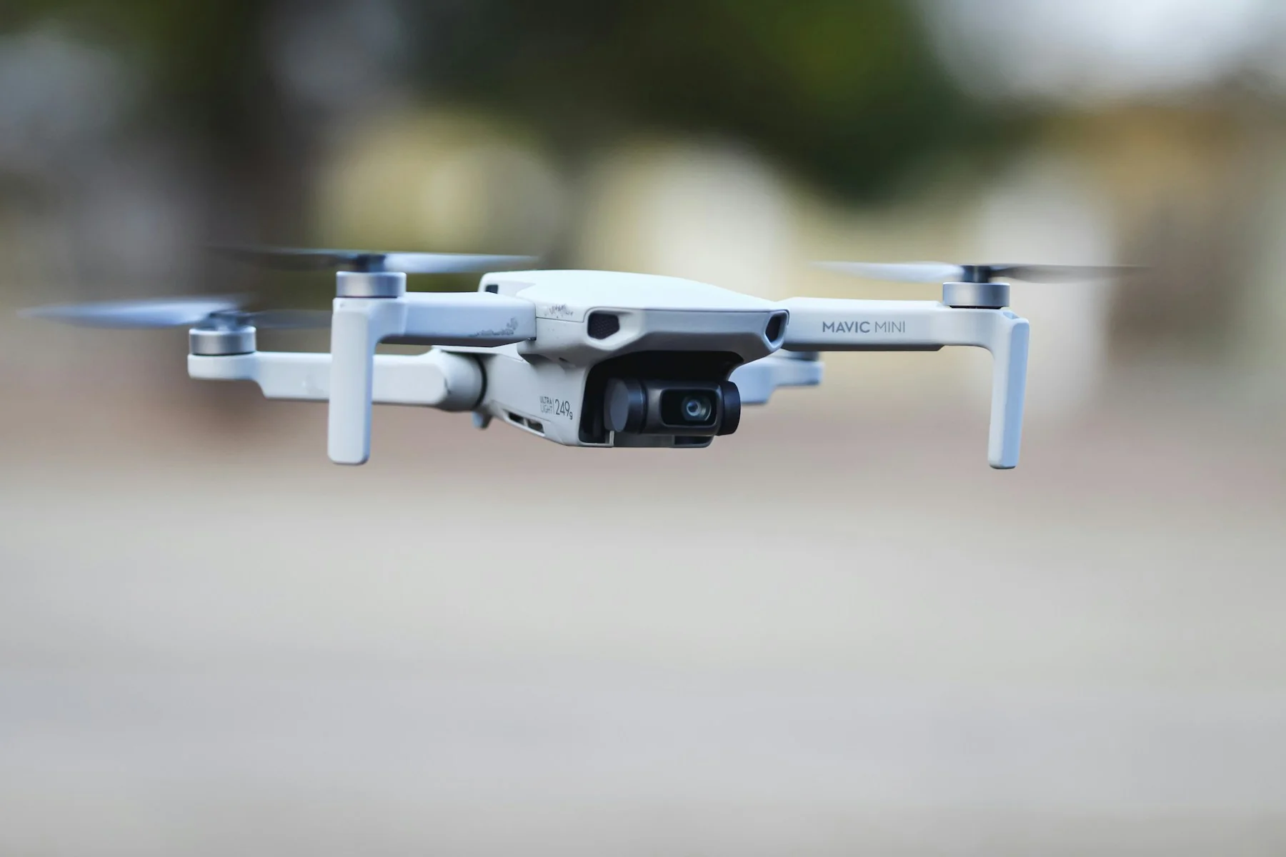 Mavic Mini photography drone hovering with its camera visible